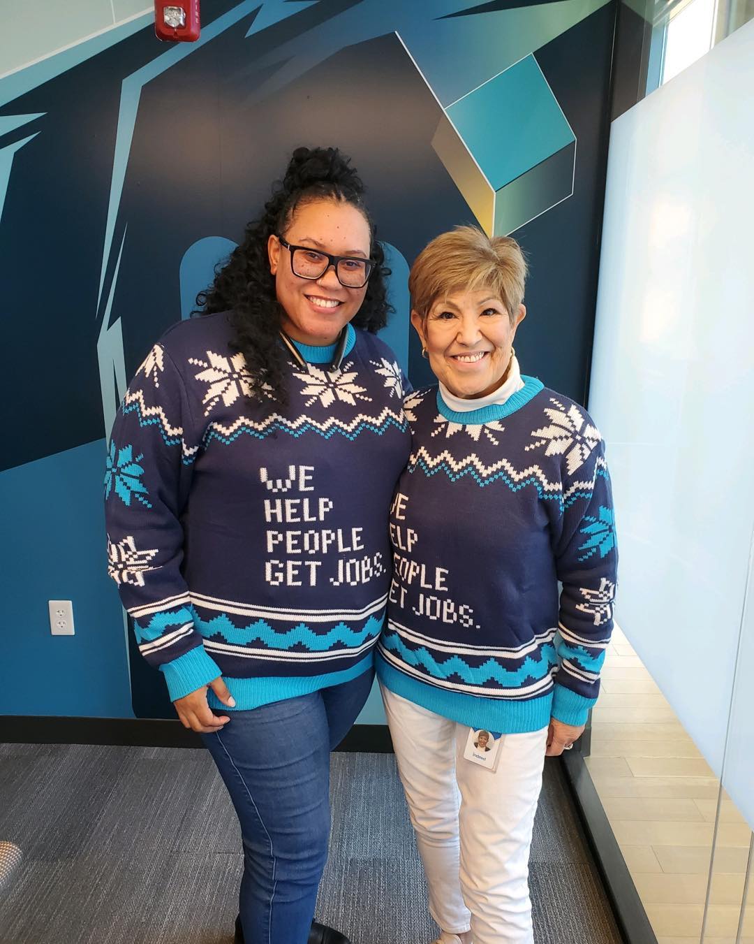 Author and co-worker pose in their Indeed Ugly Holiday sweaters 