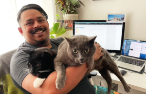 Som and his cat friend in his home office