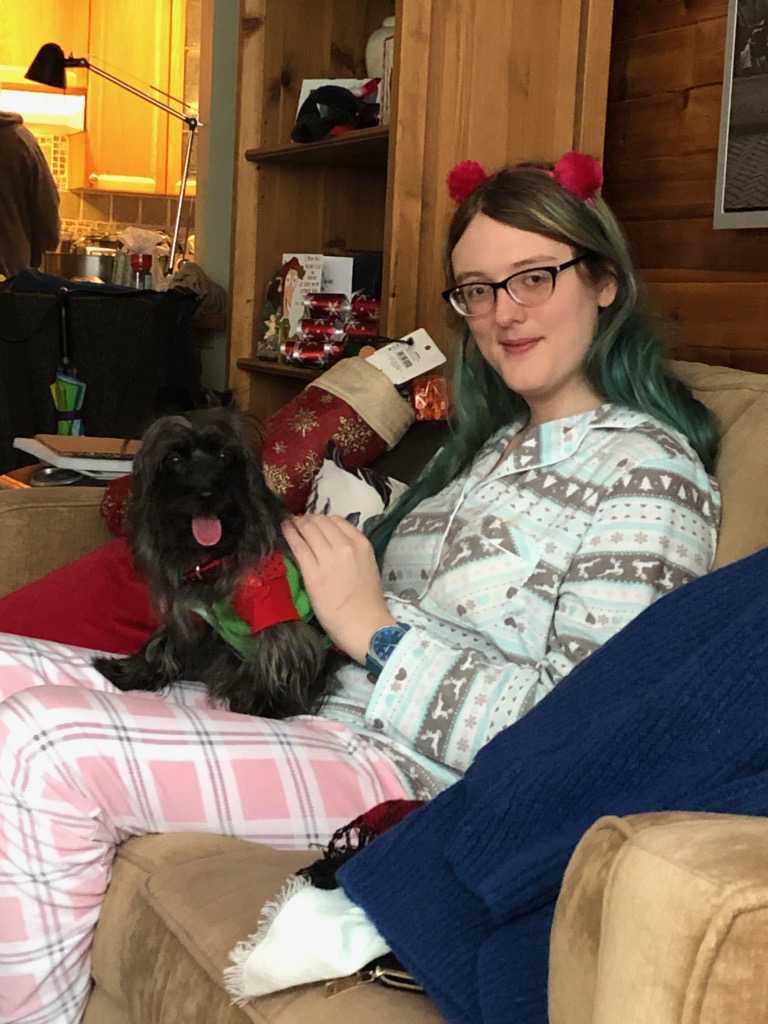 Katie wearing pajamas sitting with puppy.